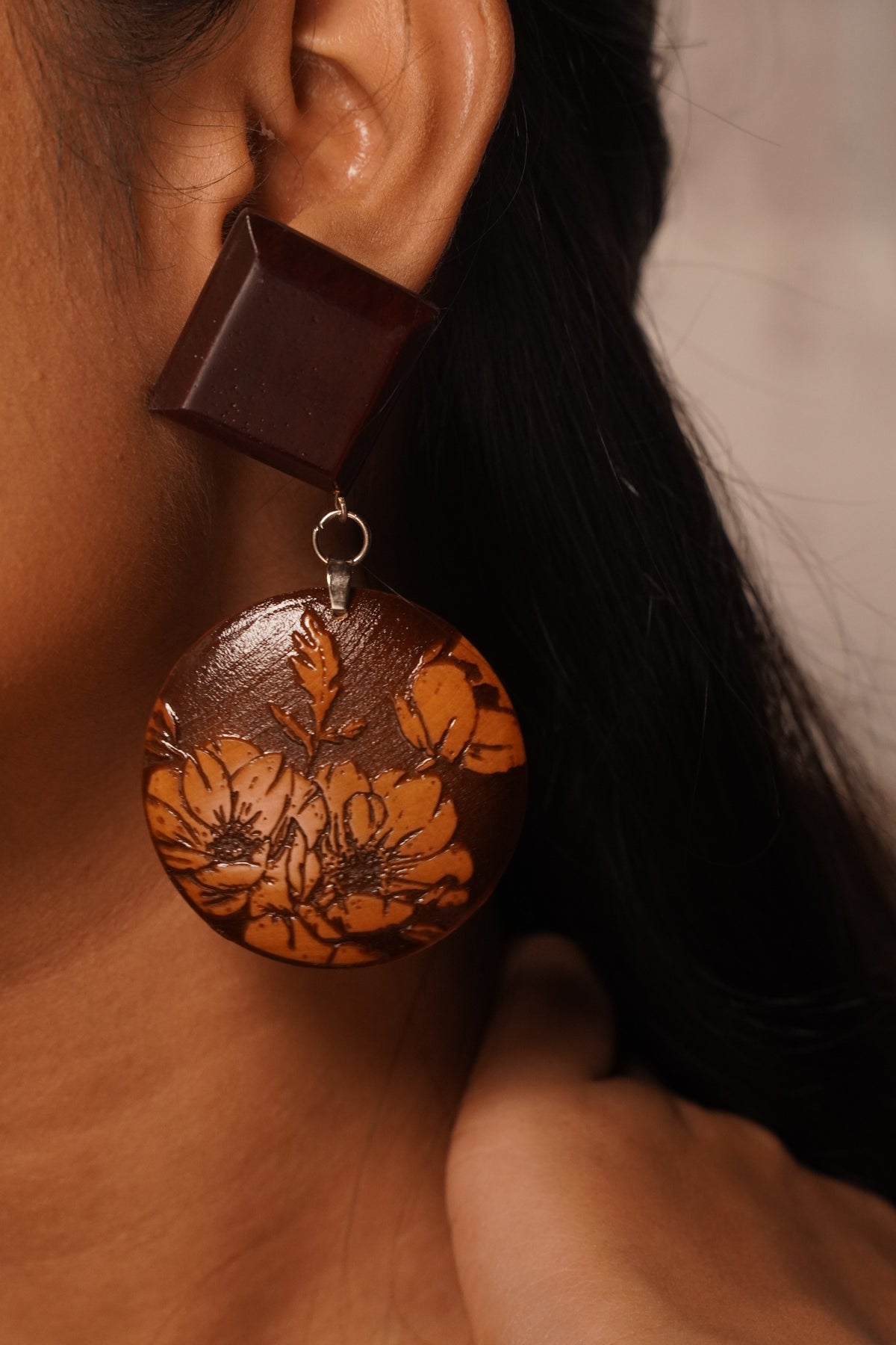 Close view of hand-engraved floral detail on Padauk wooden earrings