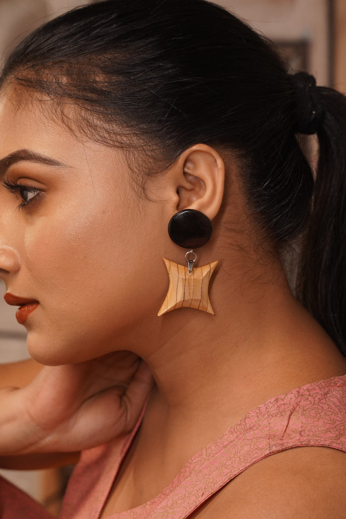 Model wearing Pankhuri wooden earrings — a domed Ebony disc above an Ebony-inlaid Maple star